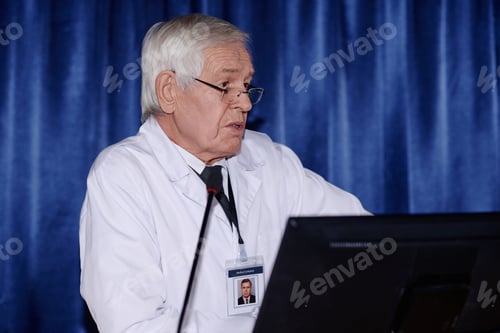 Preview: Mature doctor performing at conference