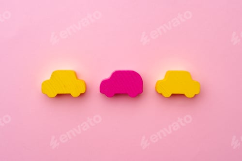 Preview: Wooden figures of toy cars on pink paper background