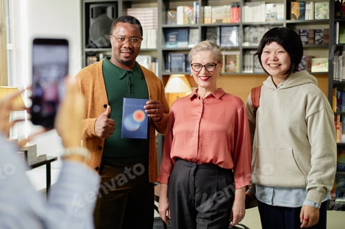 Preview: Diverse Group of Adults Smiling While Posing for Photo with Female Writer in Bookstore