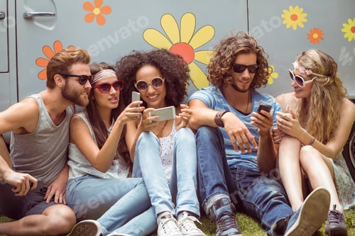 Preview: Hipster friends using their phones on a summers day
