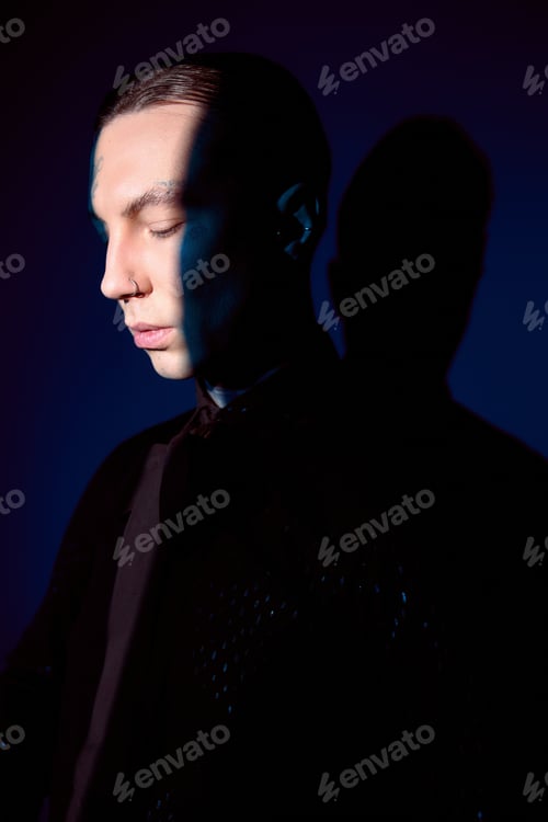 Preview: Handsome young man in stylish attire captures attention with serene expression and cool lighting