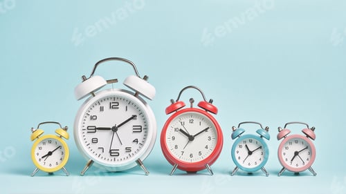 Preview: Five alarm clocks of different colors show different times.