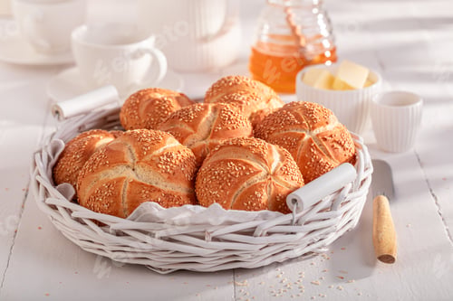 Preview: Homemade Kaiser rolls with sesame seeds, butter and honey.