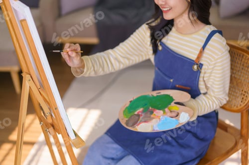 Preview: Young woman artist is imagination and creating to painting picture in canvas on easel at art studio