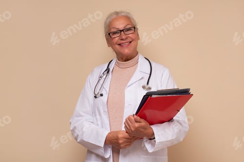 Preview: Smiling senior female doctor with stethoscope around neck