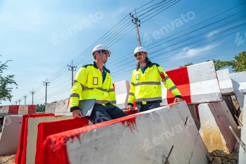 Preview: An engineer in visibility jacket and helmet working on construction site.