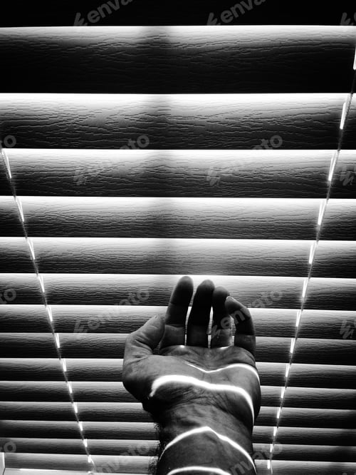 Preview: Man’s hand and palm in front of window blinds with sun and shadow black and white contrast