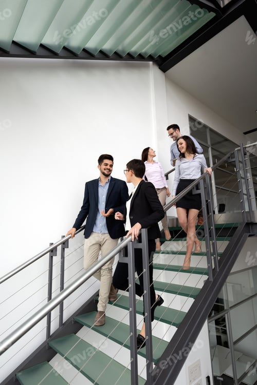Preview: Modern business people walking on stairs in glass hall in office building