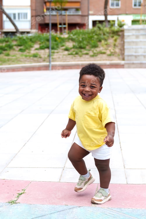 Preview: Joyful African Toddler: Radiant Smile Amidst Colorful City Park Run