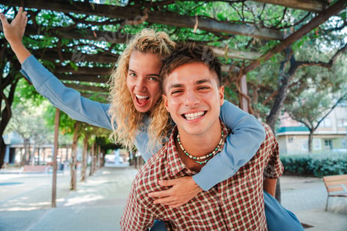 Preview: Joyful couple sharing a playful moment as one partner gives a piggyback ride while smiling brightly