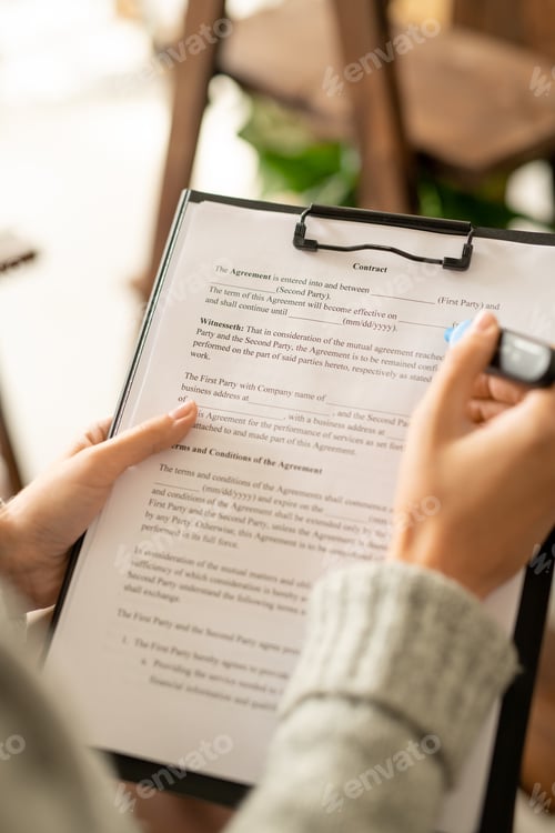 Preview: Hands of young female applicant with blue highlighter over contract on clipboard