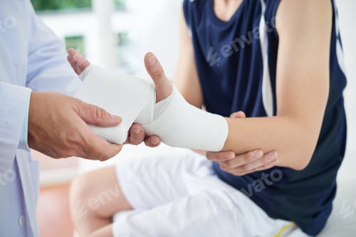 Preview: Unrecognizable doctor dressing injured hand of patient