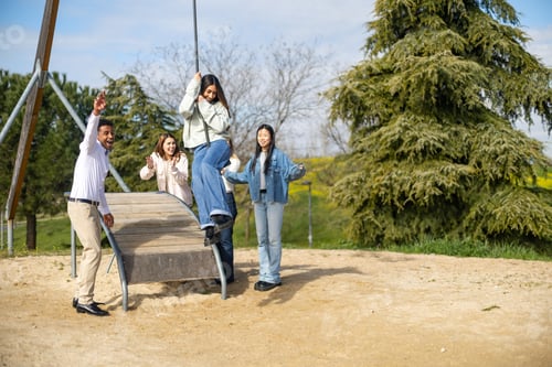 Preview: Friends playing and having fun on a swing in the park