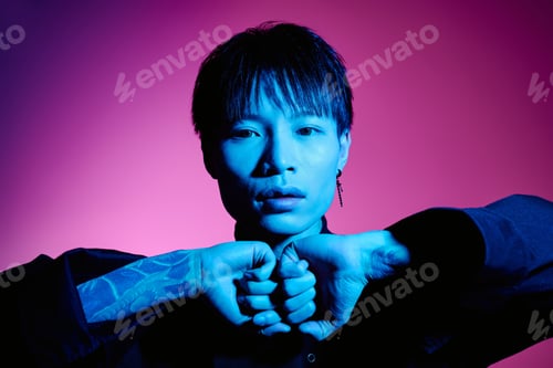 Preview: Stylish young man poses dramatically with vibrant lighting in an artistic studio setting