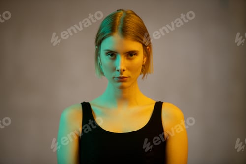 Preview: Young gorgeous blond female in black vest or leotard looking at you