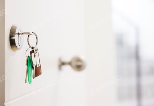 Preview: Keys hanging in door lock of new home symbolizing ownership and security