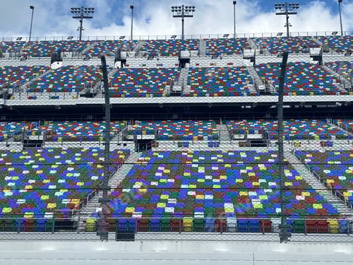 Vista previa: Coloridas sillas vacías para fanáticos o espectadores en el circuito de carreras Daytona Speedway