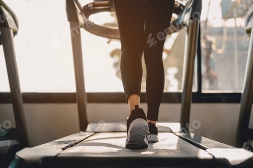 Preview: Close-up Legs and feet of women walking on the treadmill in the gym for good health and strength.