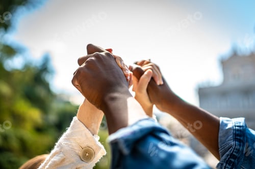 Preview: Multiracial couple holding hands on air in a park