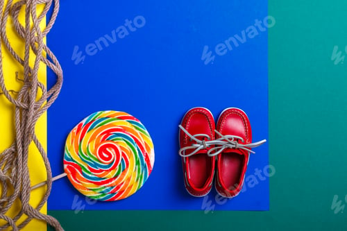 Preview: Small red boat shoes near big multi-colored lollipop