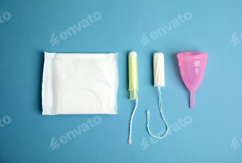 Preview: Tampon, pad and menstrual cup on blue background, flat lay