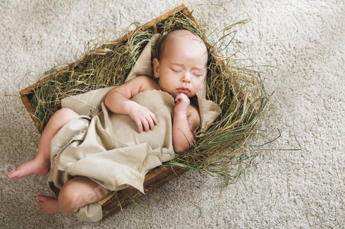 Preview: Cute baby sleeping in the box filled with a hay