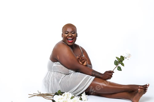 Preview: Smiling woman wearing light dress holding a flower