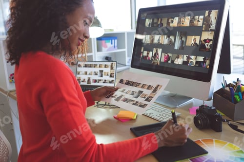 Preview: Female graphic designer writing on tablet in a modern office
