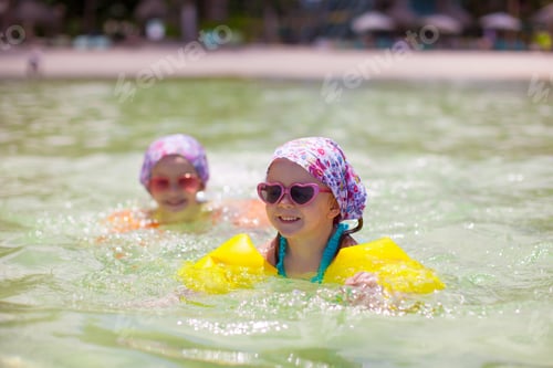 Preview: Adorable little girls swimming in clear sea