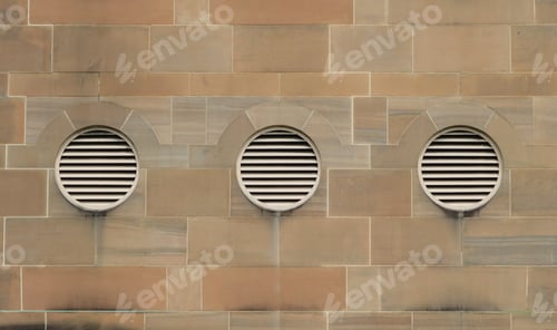 Preview: round windows with grills against sandstone wall