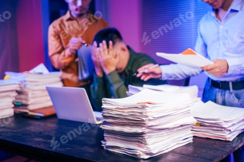 Preview: Three young businessmen work together on laptops in the office at night. They are stressed tired
