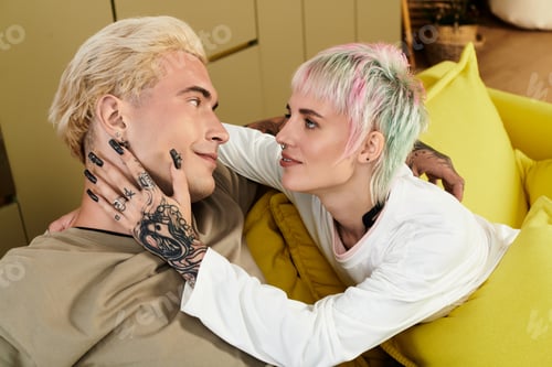 Preview: Young couple sharing an intimate moment on a cozy sofa filled with love and tenderness