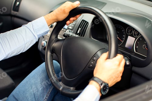 Preview: Unrecognizable businessman driving comfy auto, holding hands on steering wheel