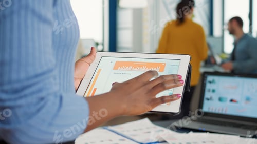 Preview: Closeup of african american woman hands picking up tablet interacting with touchscreen looking at