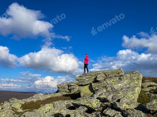 Preview: Woman hiker resting on top of giant cliffs