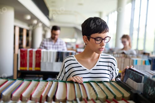 Preview: Happy group of students studying and working together in a college library