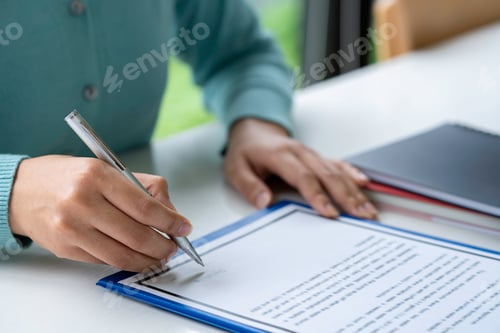 Preview: Businesswoman signing a document or application form in a folder, Woman signing document with pen on