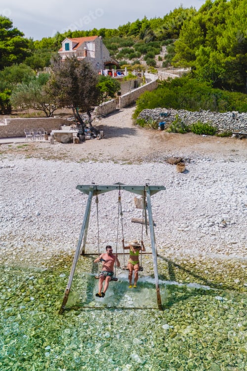 Preview: Enjoying a peaceful swing on Brac Island serene shoreline at sunset