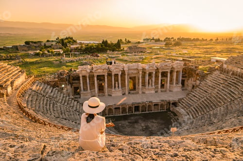 Preview: Hierapolis ancient city Pamukkale Turkey, young woman with hat watching sunset by the ruins Unesco