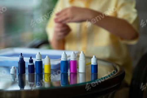 Preview: Child Creates Colorful Art with Dropper Bottles