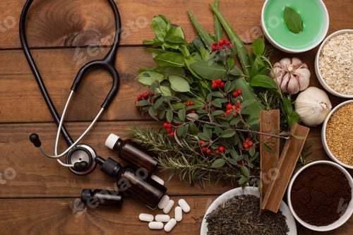 Preview: Top view of a phonendoscope next to herbs, spices, pills on a wooden surface