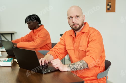 Preview: Man Using Laptop Beside Black Young Adult Man Studying