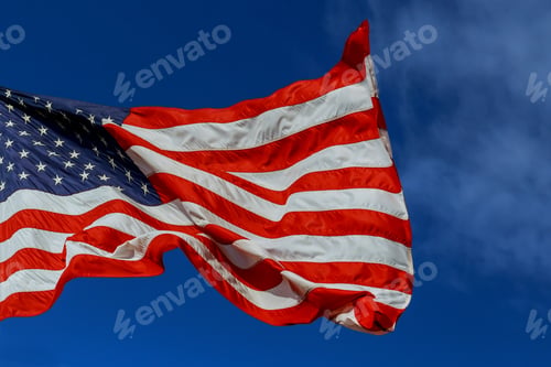 Preview: The American Flag waving in blue sky motion blur