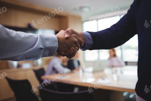 Preview: Business people shaking hands during meeting in board room