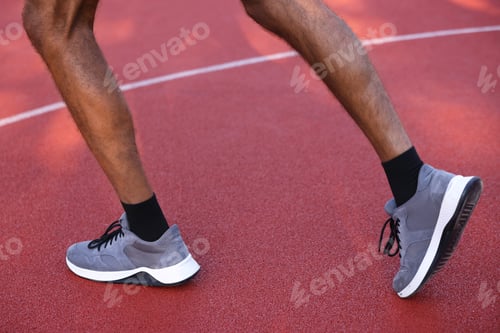 Preview: Man in sneakers running at stadium, closeup