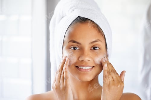 Preview: Beauty is not what you see in the mirror. Shot of young woman using with facial moisturiser.