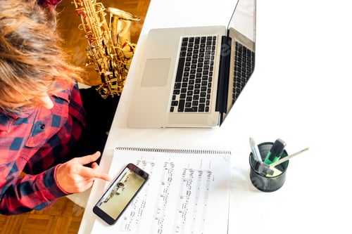 Preview: Man pointing the phone while doing the saxophone course online
