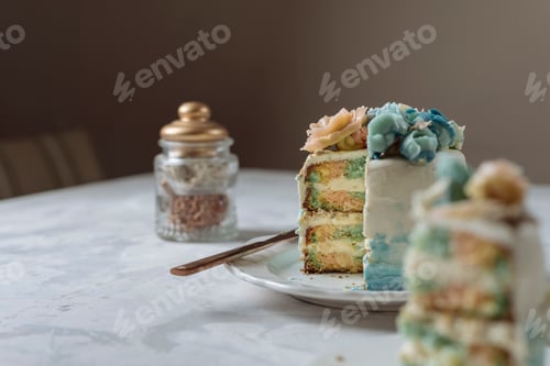Preview: Portion of rainbow cake, filled with chantilly cream, and decorated with buttercream flowers