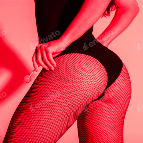 Preview: cropped view of sexy buttocks of girl in fishnet tights holding lollipop in red light