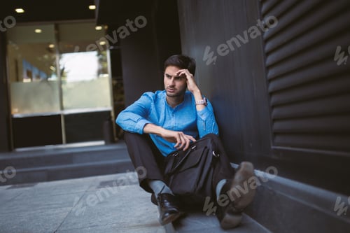 Preview: Stressful businessman with briefcase on ground